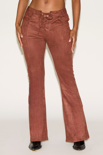 Brown flared pants worn by a person on a white background