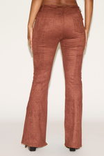 Brown flared pants worn by a person on a white background