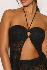 Black crochet top worn by a model on a white background