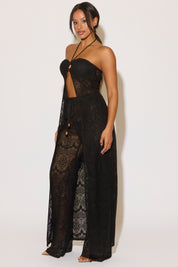 Woman wearing a black lace jumpsuit against a white background