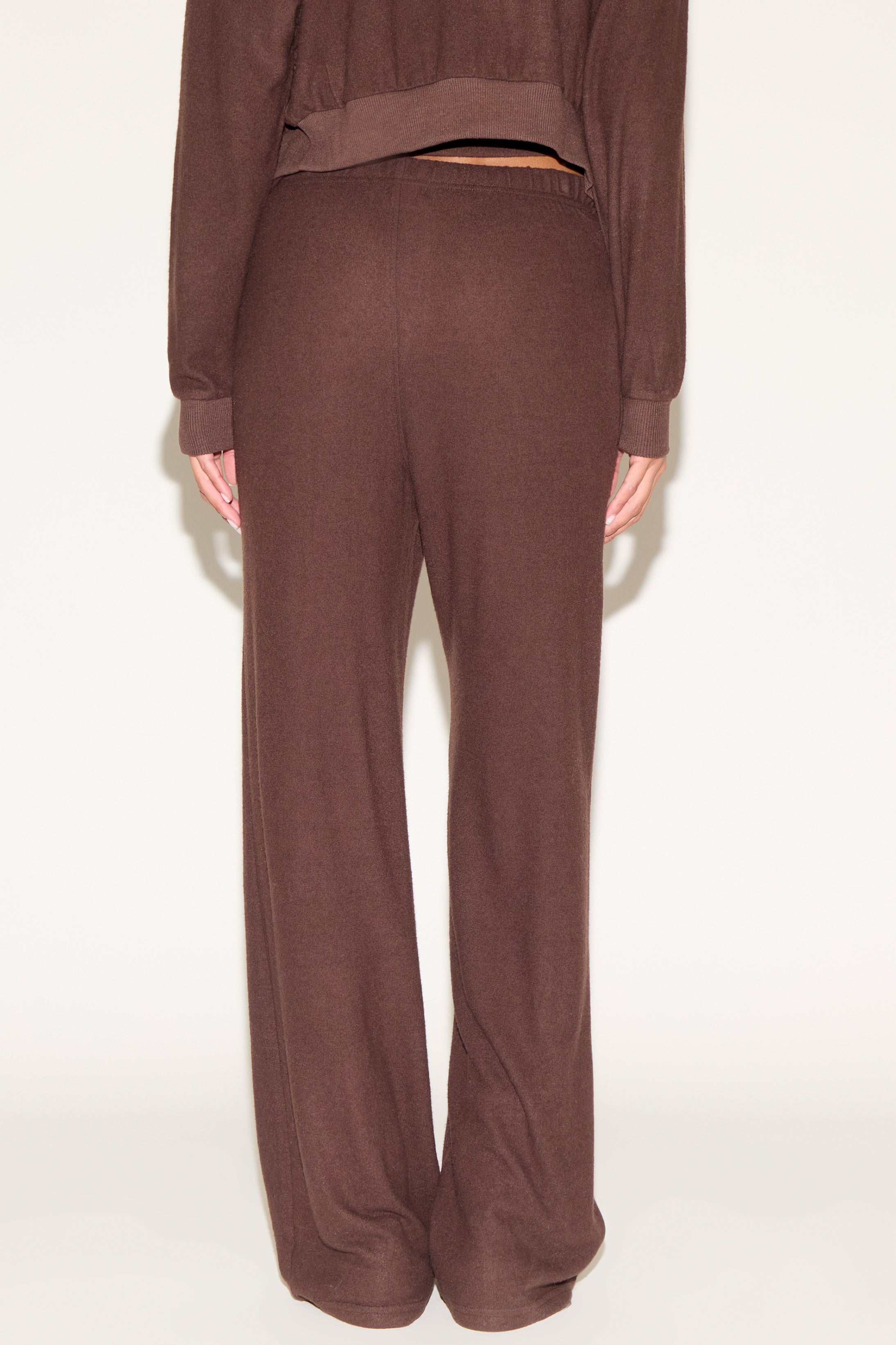 Brown sweatshirt and pants set on a white background