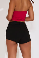 Person wearing a red top and black shorts on a white background
