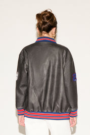 Person wearing a gray leather jacket with colorful accents on a white background