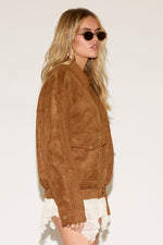 A women wearing a brown jacket in a white background.