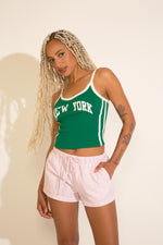 A green and white tank top with 'NEW YORK' text on the front, featuring contrast trim.