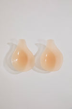 Pair of beige silicone cups on a white background