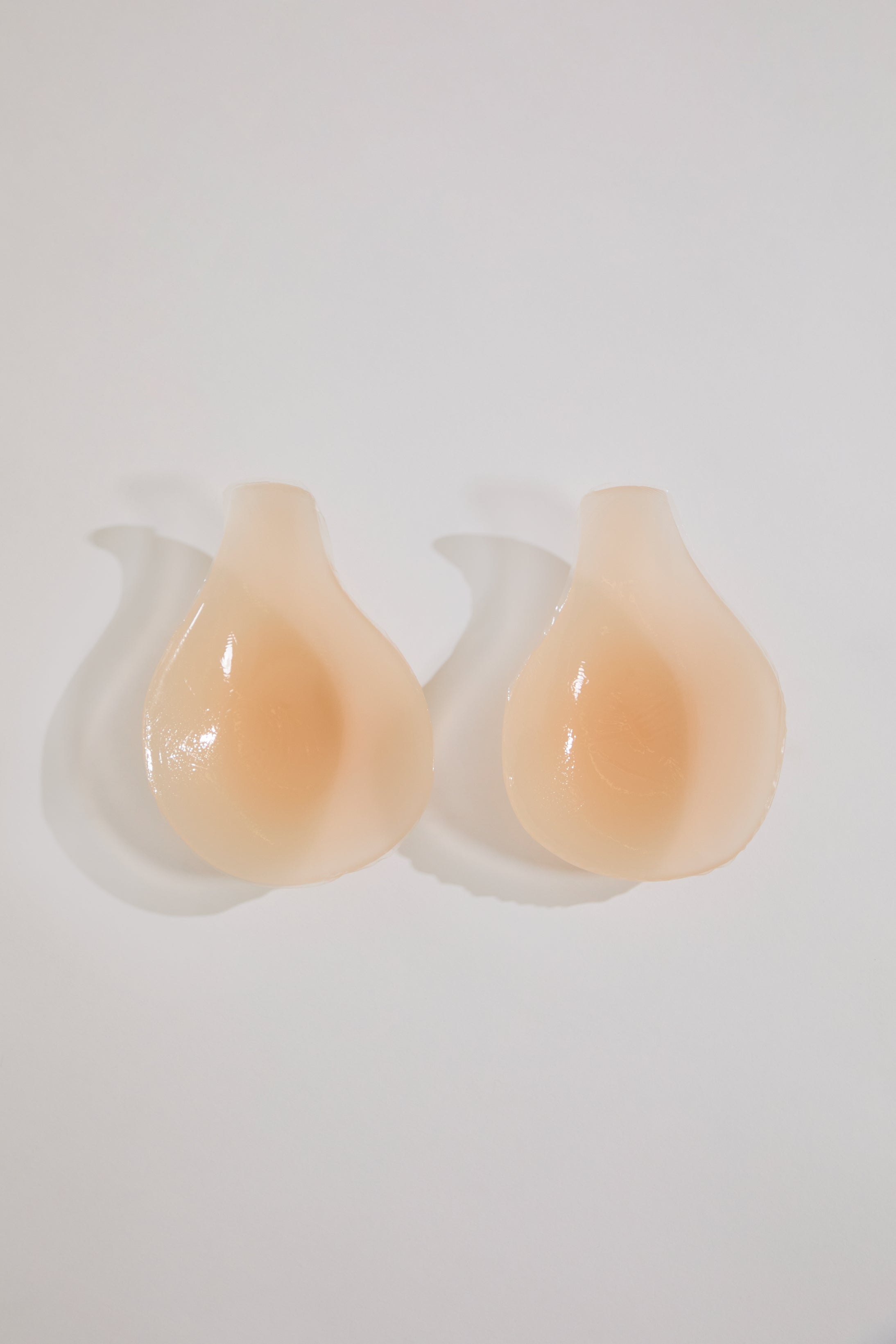Pair of beige silicone cups on a white background