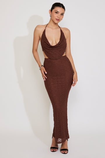 Woman wearing a brown halter neck dress against a white background
