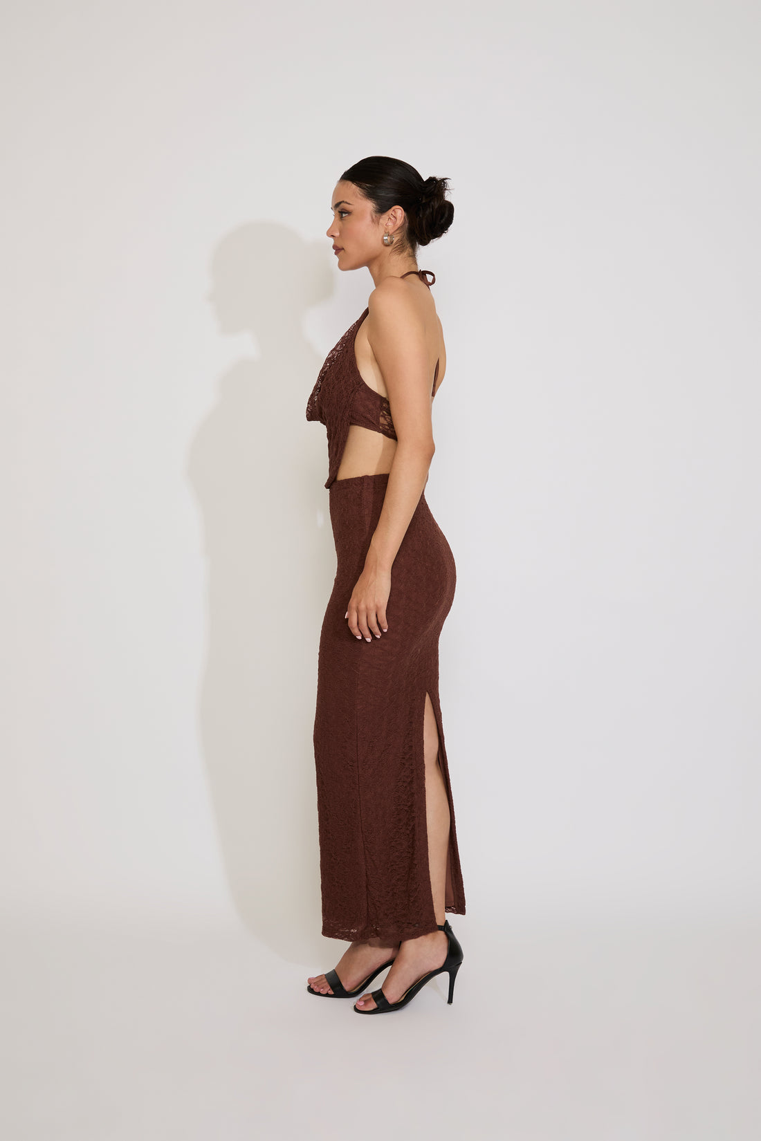 Woman wearing a brown halter neck dress against a white background