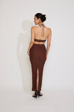 Woman wearing a brown dress with a sheer overlay on a white background