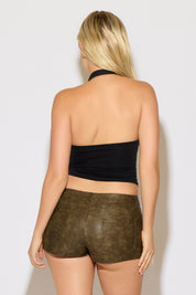 Model is wearing a black halter top with rhinestones shaped as a cross with brown leather shorts on a white background.  