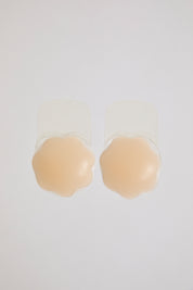 Beige silicone bra pads on a white background