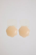 Beige silicone bra pads on a white background