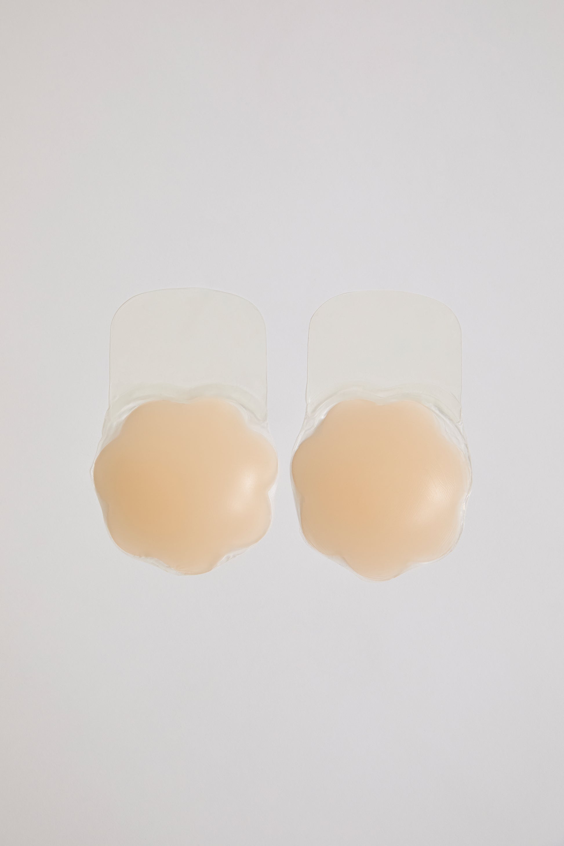 Beige silicone bra pads on a white background