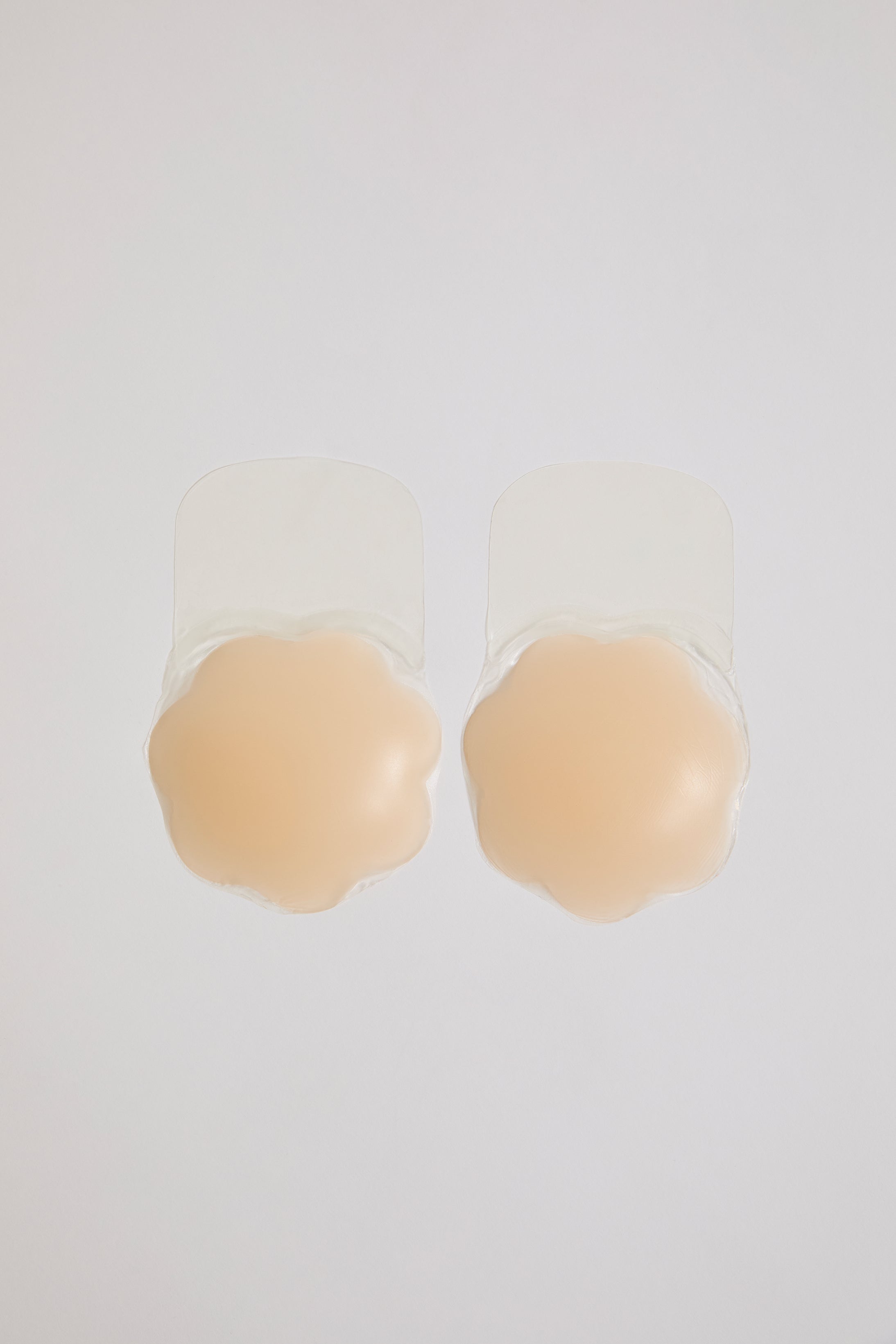 Beige silicone bra pads on a white background