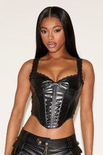 Woman wearing a black leather outfit against a plain background