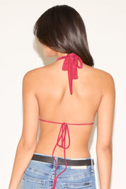 Woman wearing a red halter top with thin straps on a white background