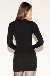 Woman wearing a black long-sleeve dress against a white background
