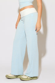 Model is wearing a contrast fold over waist striped pants with green shoes on a white background.