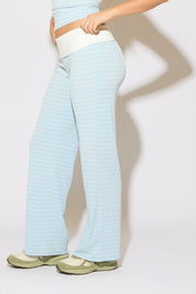 Model is wearing a contrast fold over waist striped pants with green shoes on a white background.
