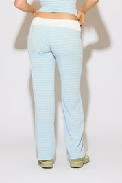 Model is wearing a contrast fold over waist striped pants with green shoes on a white background.