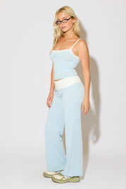 Model is wearing a contrast striped cami top with matching fold over waist stripped pants on a white background.