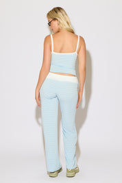 Model is wearing a contrast striped cami top with matching fold over waist stripped pants on a white background.