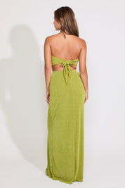 Model is wearing a green metal detail strapless cutout maxi dress on a white background.