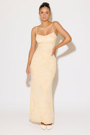 Woman wearing a yellow printed dress on a white background