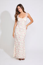 Model is wearing white and pink ROSE PRINT RUFFLE STRAP V NECK MAXI DRESS with black heels on a white background.
