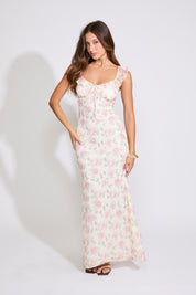 Model is wearing white and pink ROSE PRINT RUFFLE STRAP V NECK MAXI DRESS with black heels on a white background.