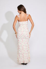 Model is wearing white and pink ROSE PRINT RUFFLE STRAP V NECK MAXI DRESS with black heels on a white background.