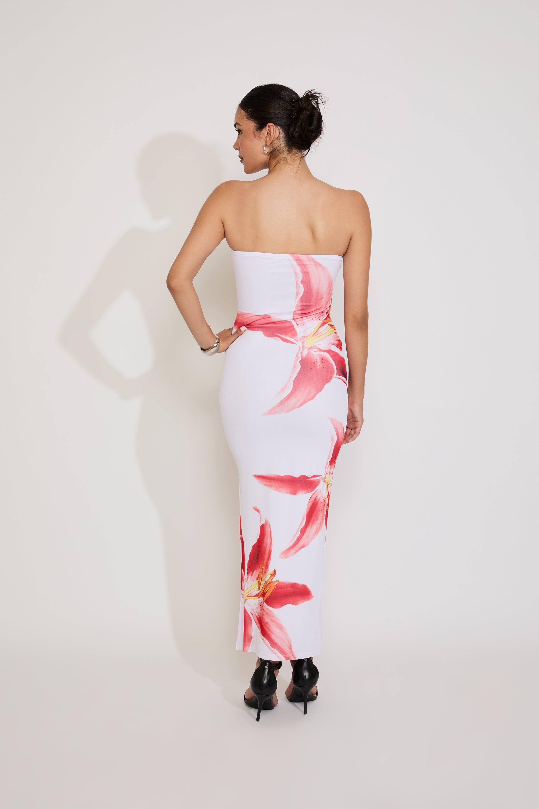 Woman wearing a strapless floral dress against a white background