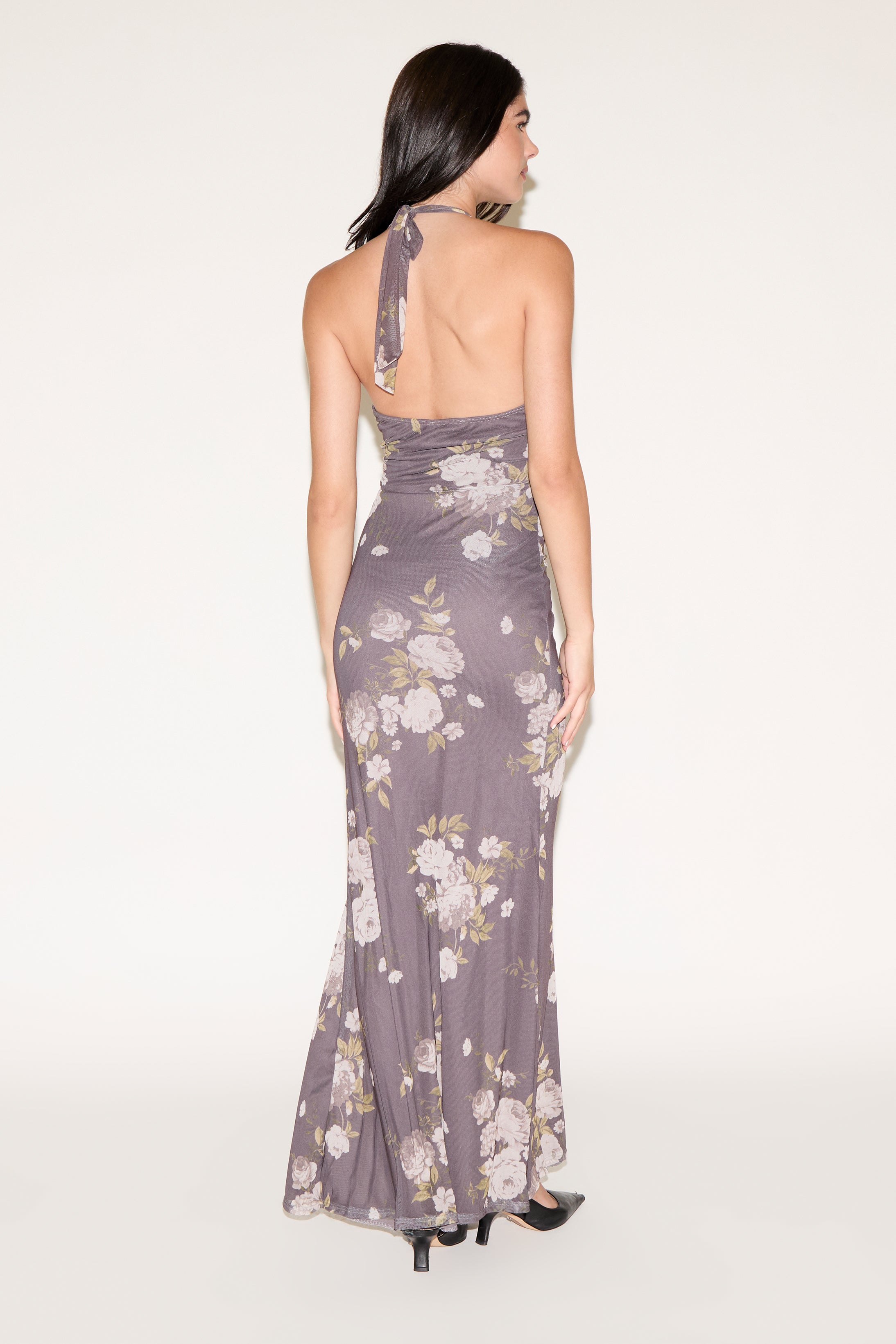 Woman wearing a floral purple dress on a white background