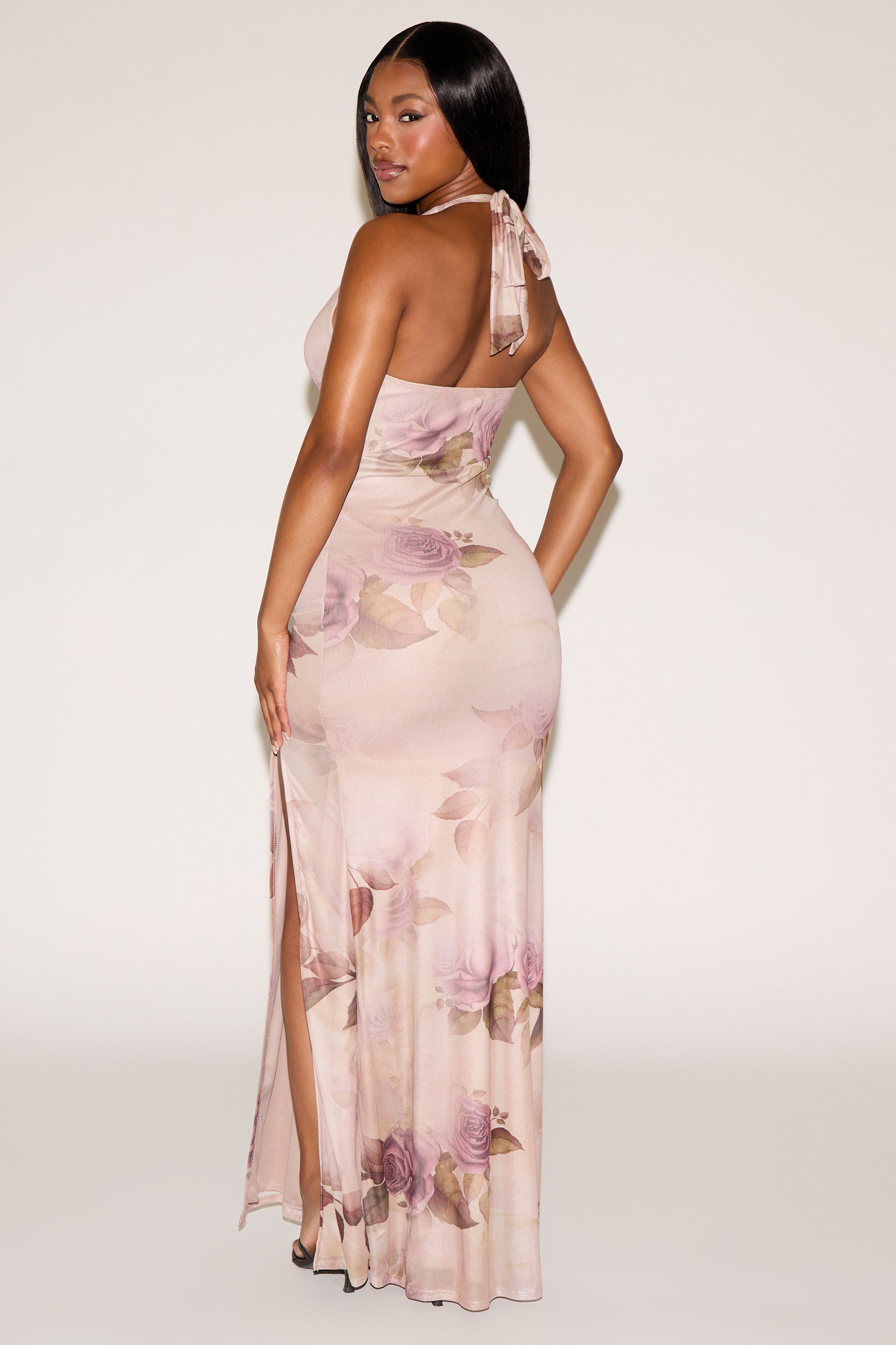 Woman wearing a floral evening gown against a white background