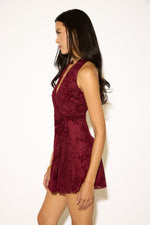 Woman wearing a burgundy floral dress against a white background