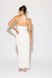 Woman wearing a white strapless gown with a plain background