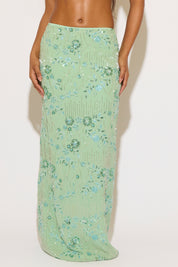 Green floral skirt worn by a person on a white background