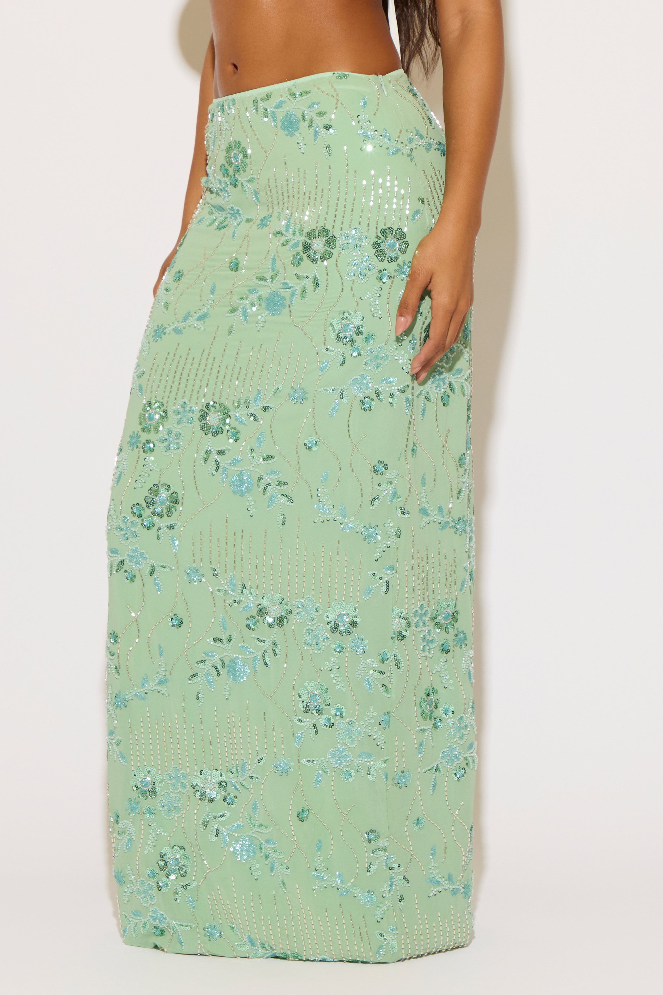 Green floral dress worn by a person on a white background