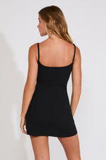 Woman wearing a black dress against a white background