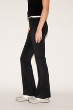Person wearing black wide-leg pants on a white background