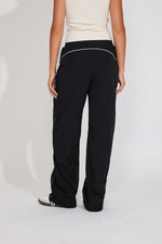 Black pants worn by a person on a white background
