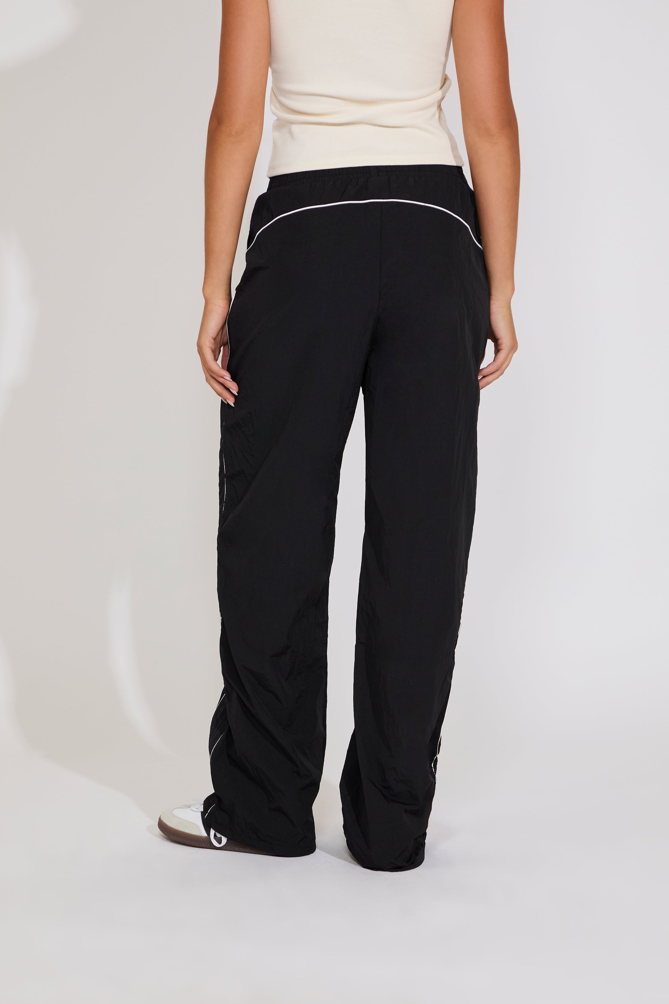 Black pants worn by a person on a white background