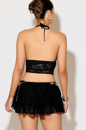 Woman wearing a black lace outfit against a white background