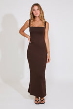 Woman wearing a brown dress against a white background