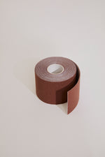 Roll of sandpaper on a light beige background