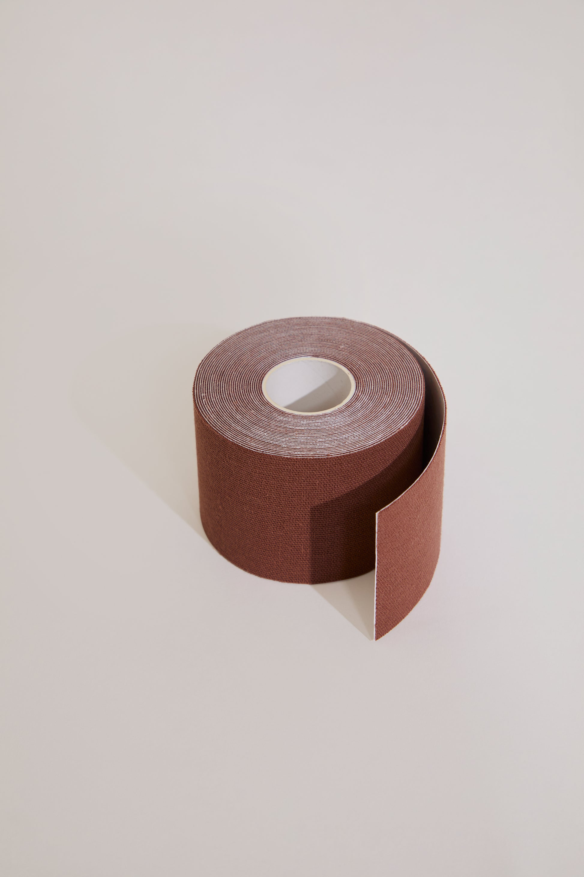 Roll of sandpaper on a light beige background