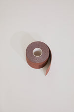 Roll of brown tape on a light gray background