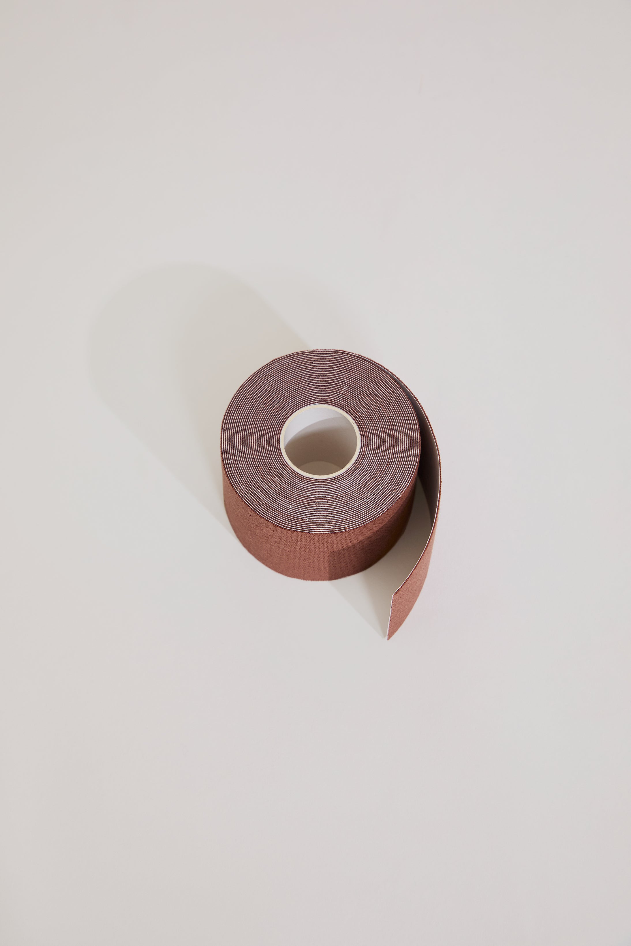 Roll of brown tape on a light gray background