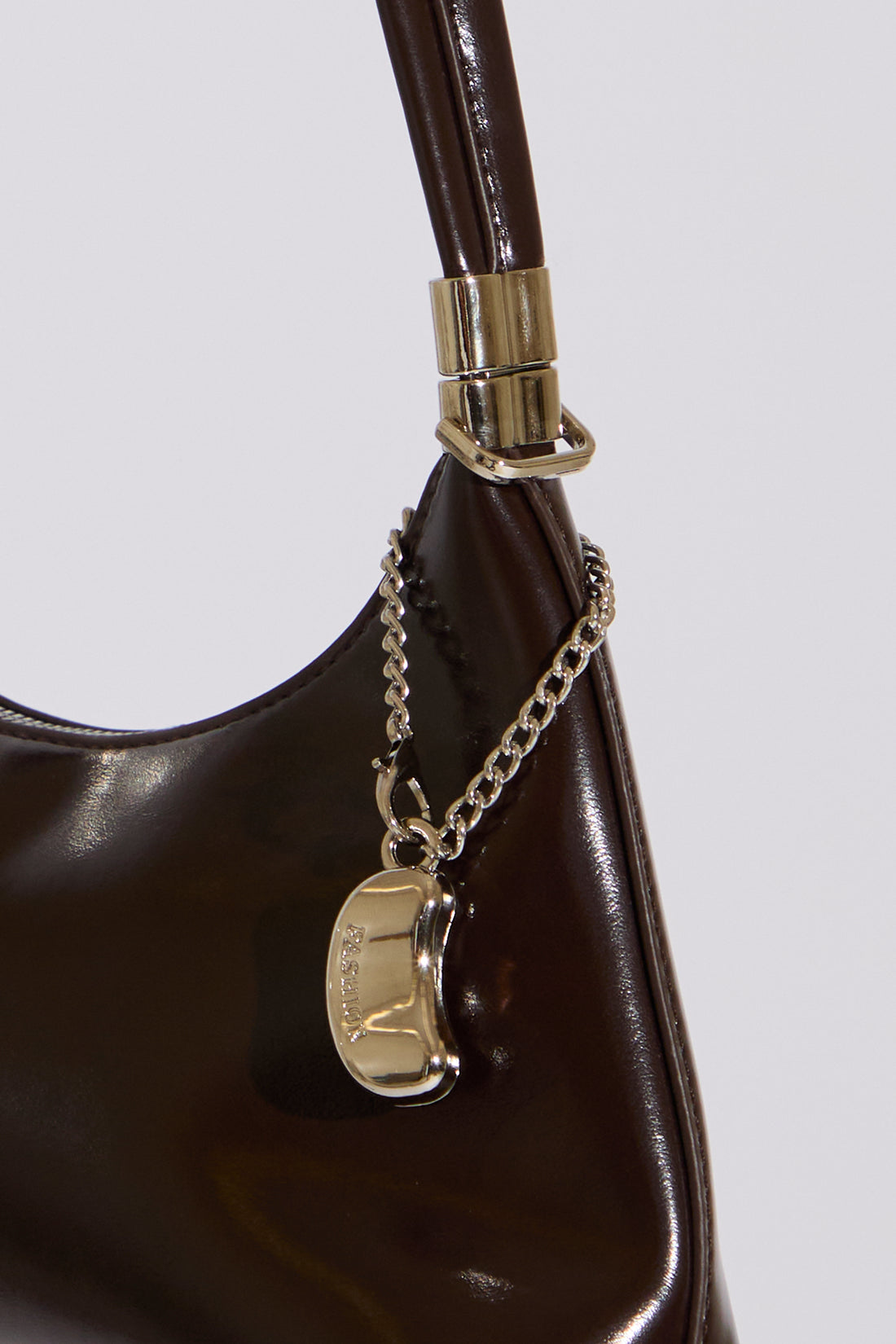 Brown handbag with a chain detail on a light gray background